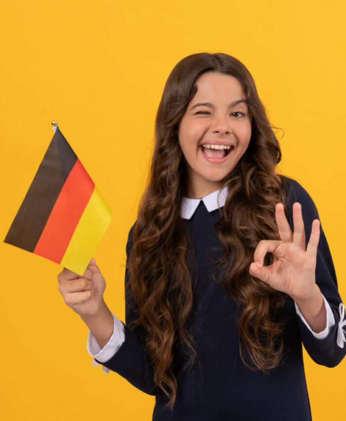 happy-winking-child-hold-german-flag-yellow-background-showing-ok-gesture-education-abroad