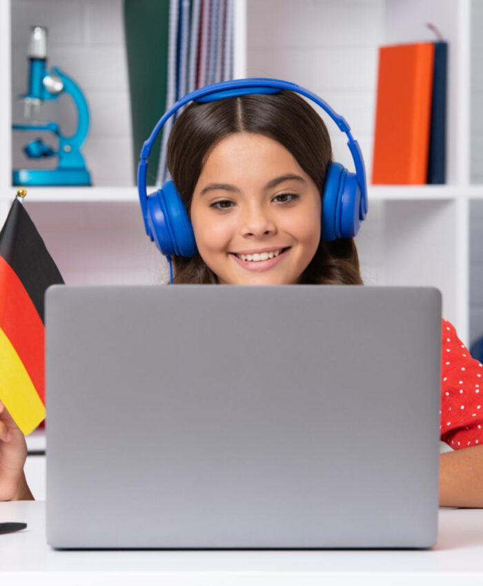young-school-girl-student-sitting-table-using-laptop-when-studying-happy-girl-hold-german
